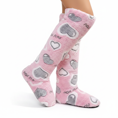 Pink fluffy knee-high slipper boots with grey and white heart pattern - side view